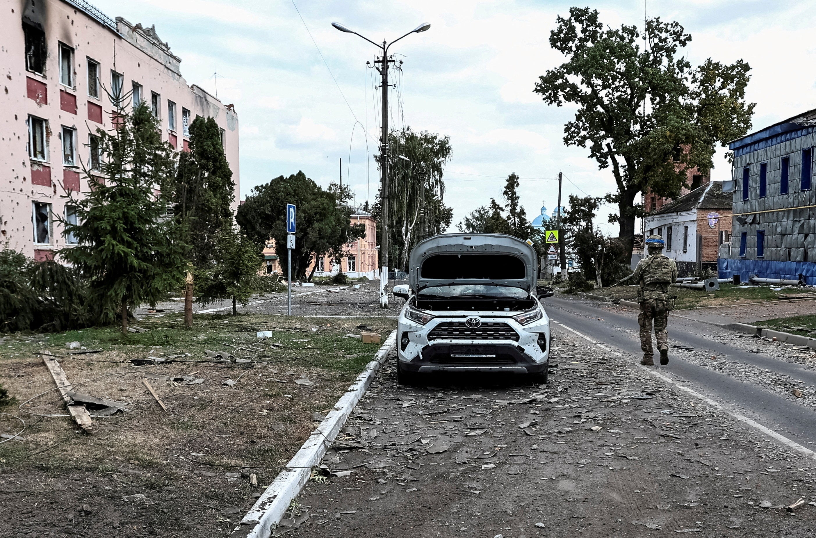 A Ukrainian serviceman patrols a street next to buildings damaged during recent fighting between Ukrainian and Russian forces in the Ukrainian-controlled town of Sudzha in Russia's Kursk region in August