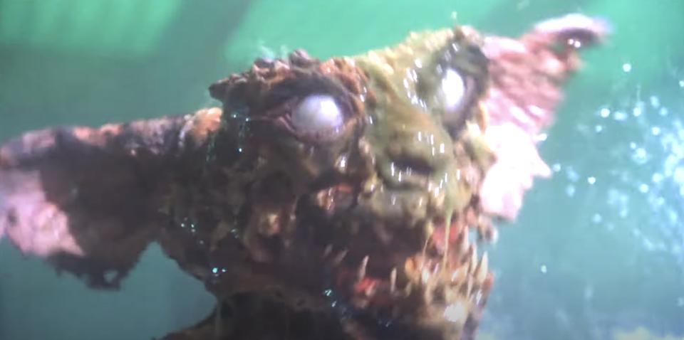 Fantasy creature with large ears, glowing eyes, and rough, textured skin in a dramatic underwater scene
