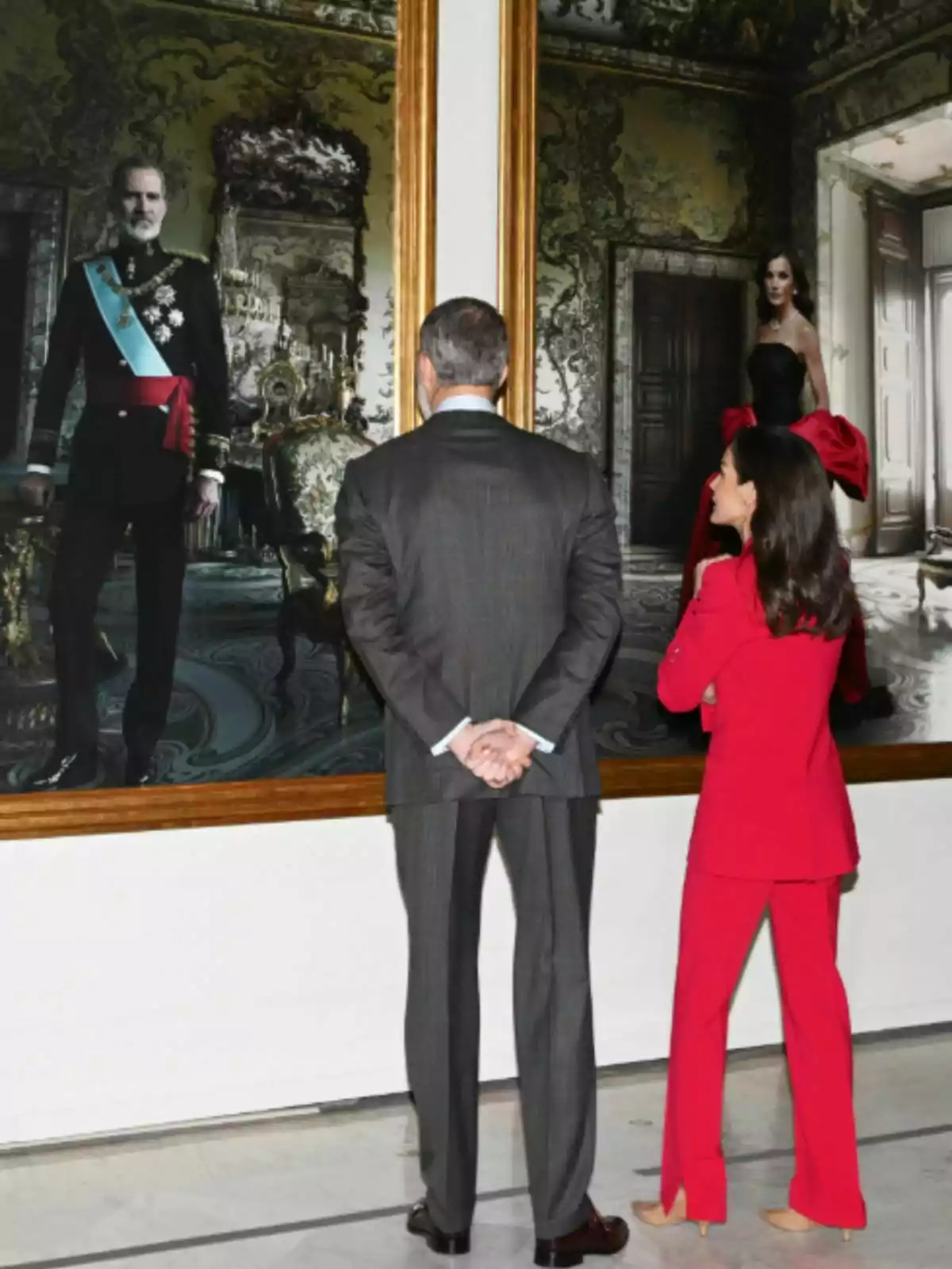 Felipe VI and Queen Letizia carefully observe a pair of framed portraits in an art gallery.