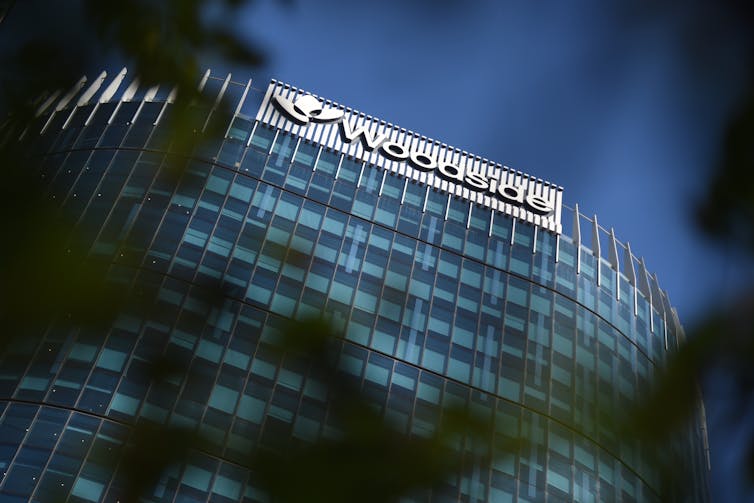 tall office building with sign at top reading 'Woodside'