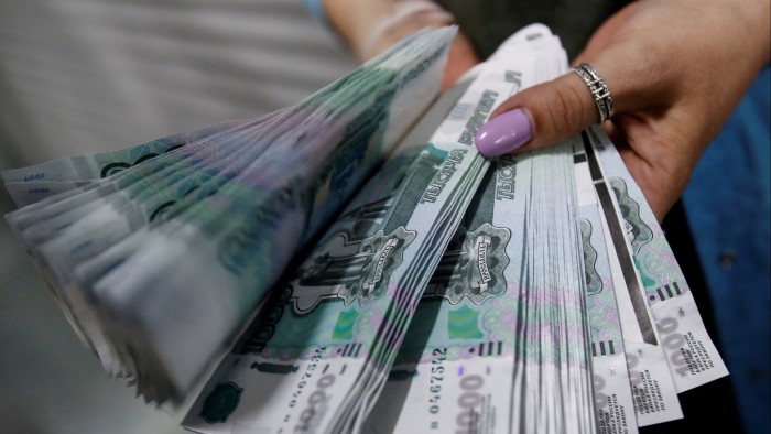 Investors seek to profit from Russia as Trump pursues rapprochement Person holding Russian rouble bill
