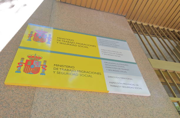 A sign on a building for the Spanish Ministry of Labor, Migrations, and Social Security, featuring the Spanish coat of arms.