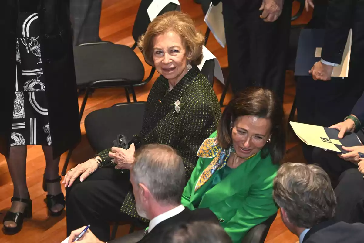 People sitting in a conference room talking and smiling.