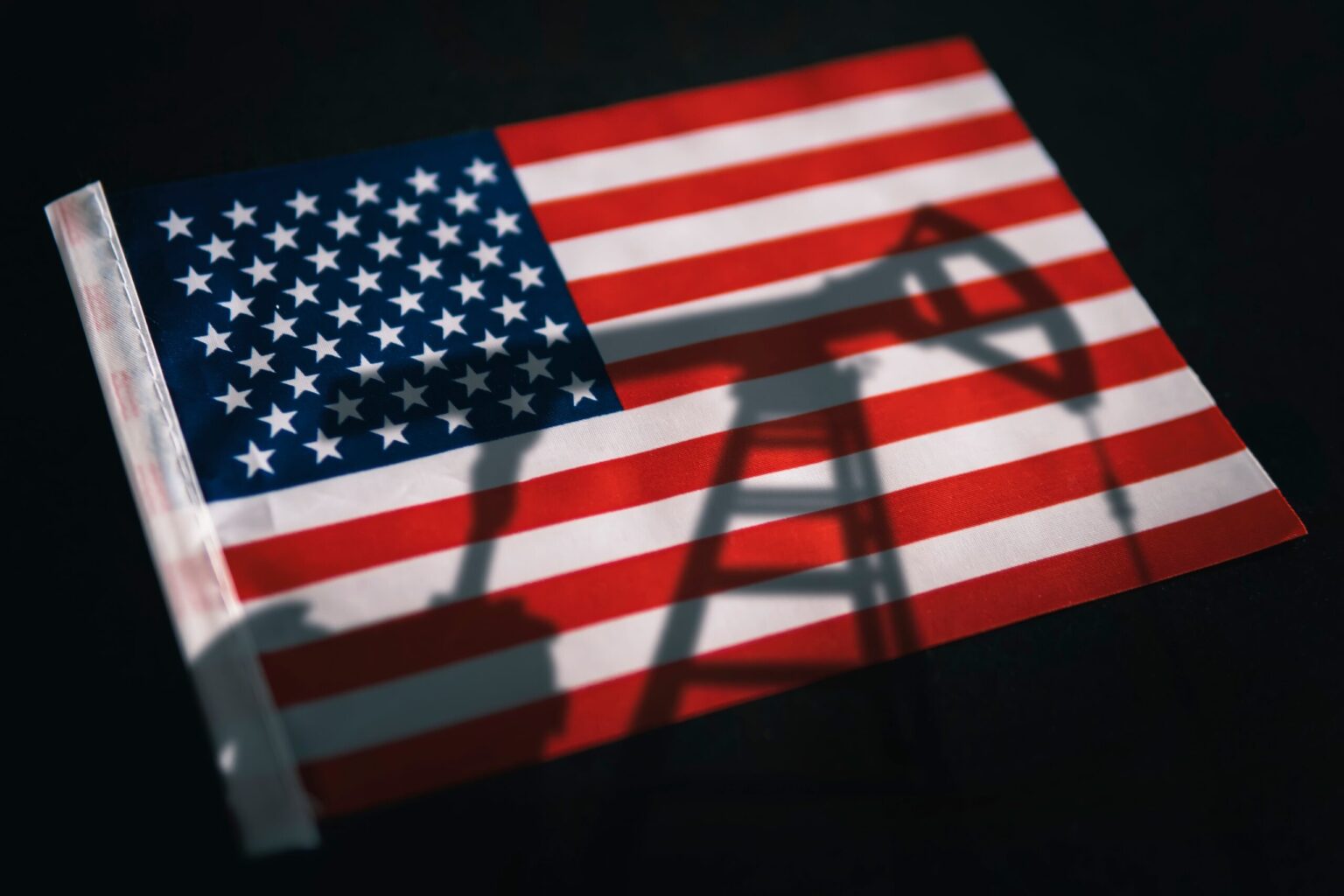 Shadow of an oil pump on the American flag, symbolizing how energy abundance isn't a climate strategy