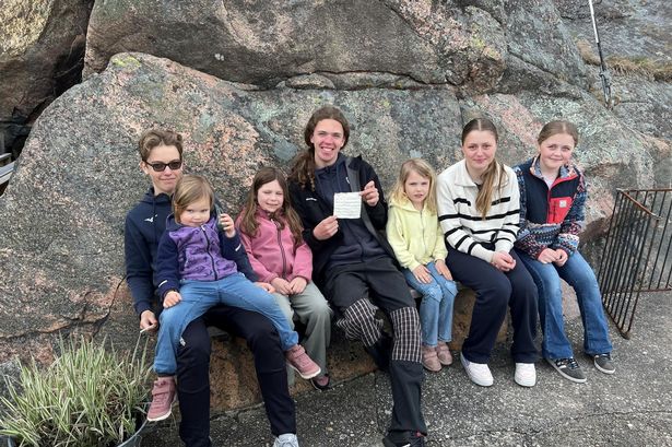Photo shows the children who found a message in a bottle holding up the handwritten note