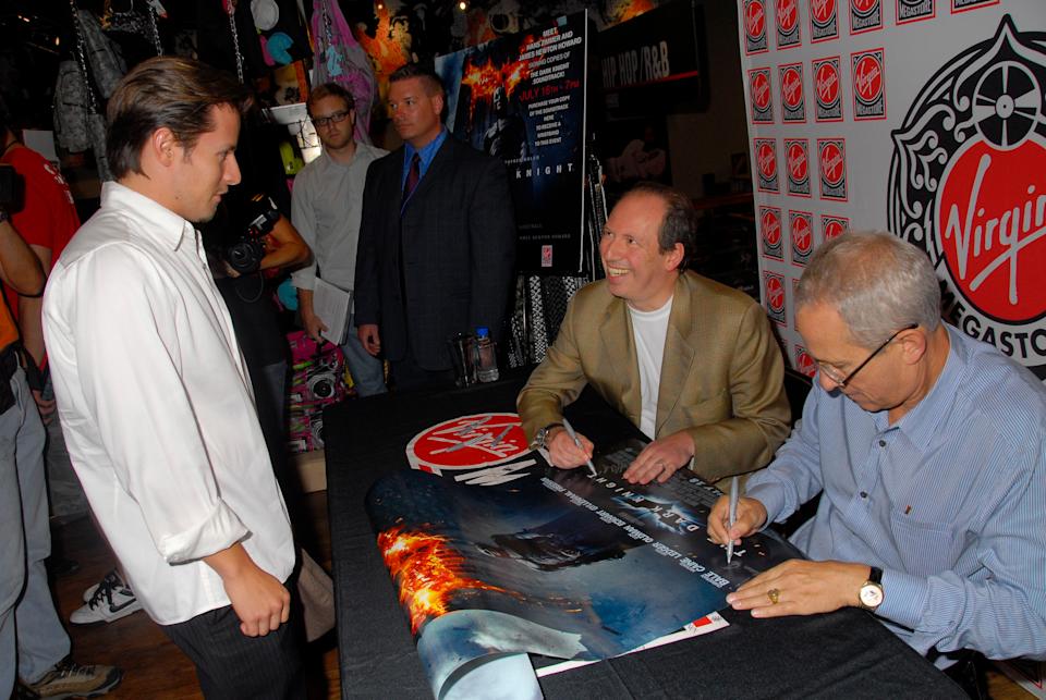 Zimmer and James Newton Howard sign movie posters at a table inside a Virgin Megastore.