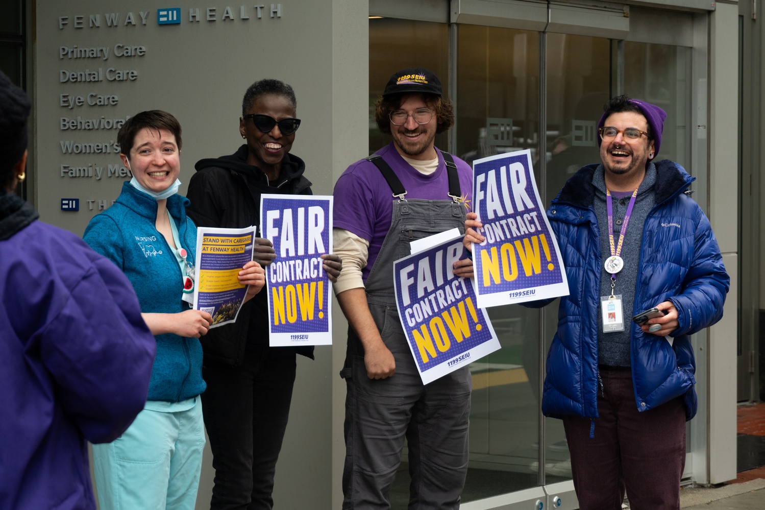 Members of Fenway Health United rally outside of Fenway Health Community Center, handing out posters and holding up signs that read "Fair Contract Now!"