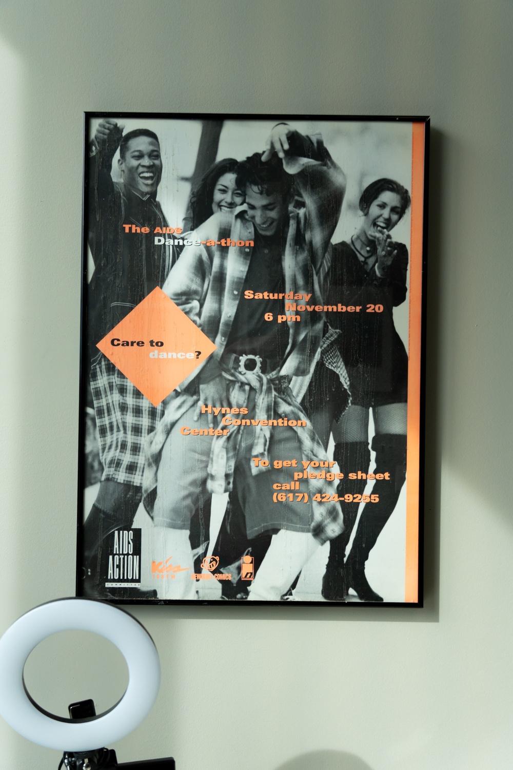 A framed poster in Fenway Health's offices, advertising an AIDS dance-a-thon.