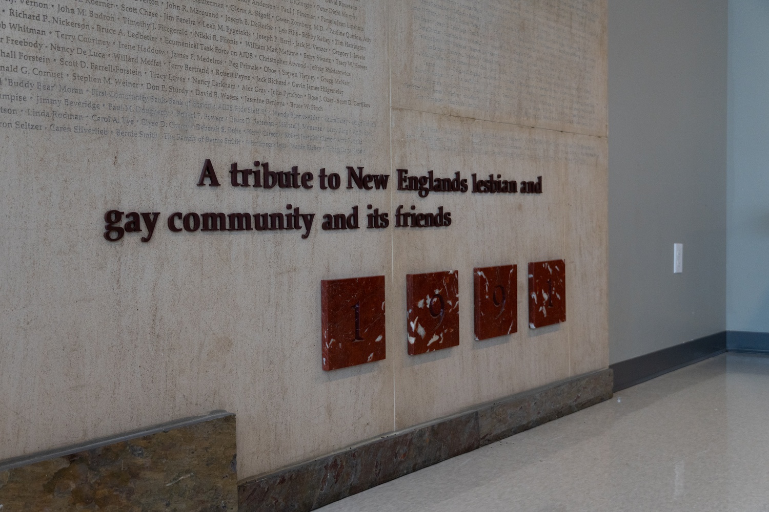 A wall in Fenway Health's building inscribed with the name of donors and dedicated to "New Englands gay and lesbian community and its friends."