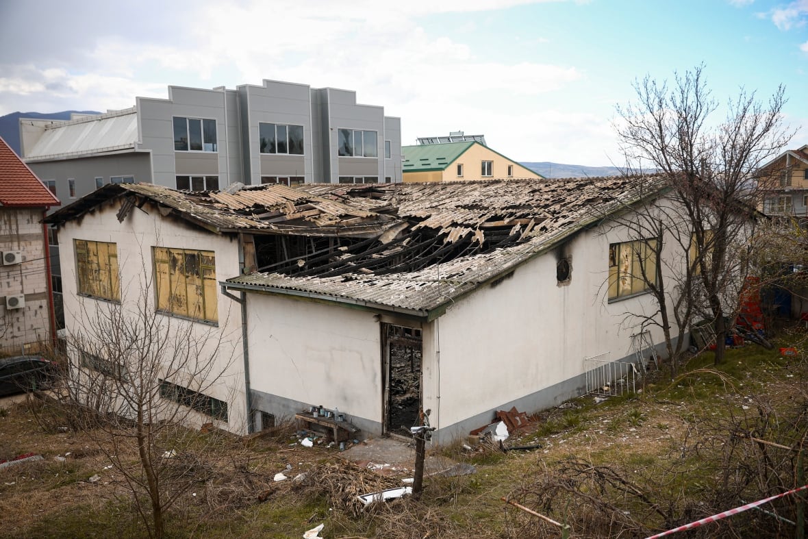 The damaged rickety roof of a one-storey building is shown.