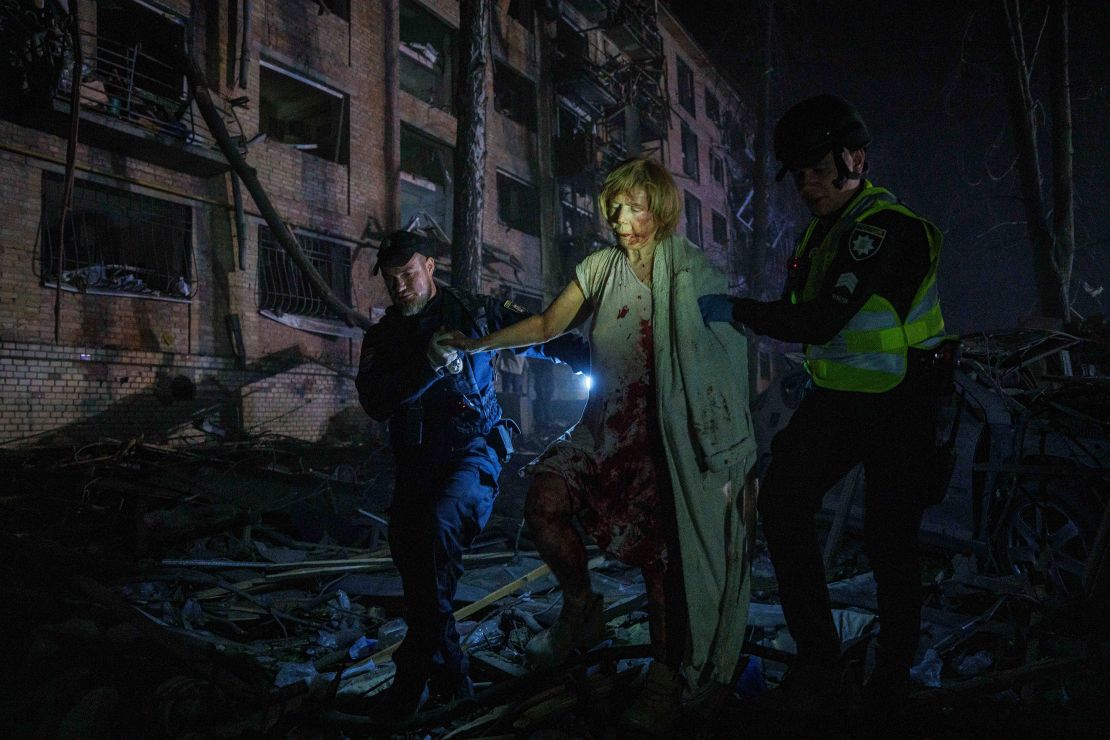 Police officers help an injured woman leave her house, which was damaged by a Russian airstrike, in a residential neighbourhood in Kyiv, Ukraine, on Thursday.