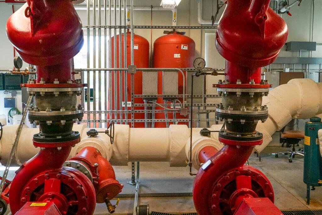 A series of red and blue pipes inside a mechanical room at Colorado Mesa University
