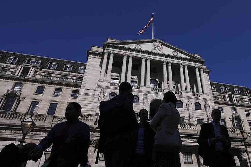 FILE - People are silhouetted as they pass The Bank of England in London, Thursday, April 3, 2025. (AP Photo/Kirsty Wigglesworth, File)