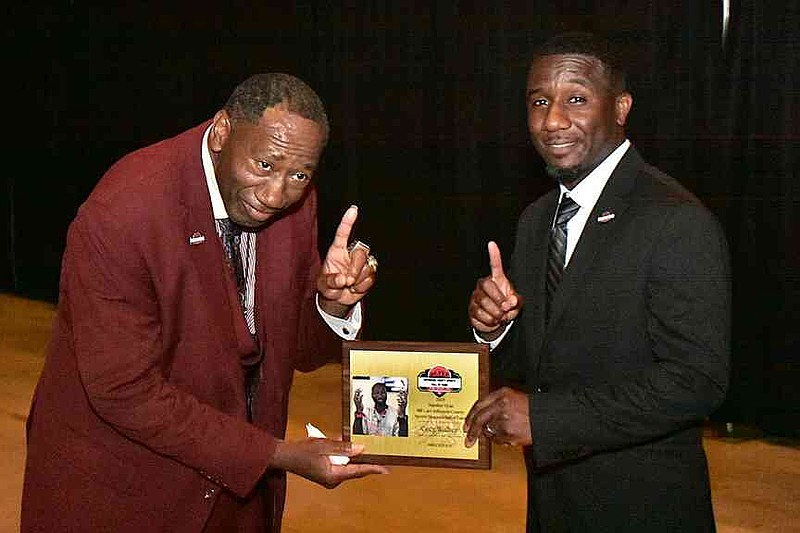 Greg Walker receives a special award from Pine Bluff/Jefferson County Library System Director Ricky Williams for his dedication as a Pine Bluff High School team manager and top fan. (Pine Bluff Commercial/I.C. Murrell)