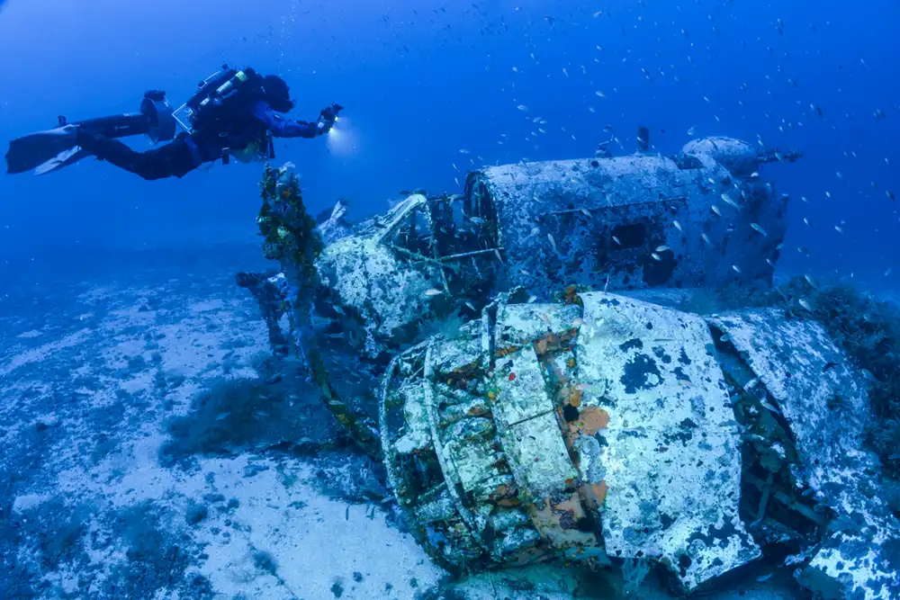 wreckage of baltimore fw282 bomber aircraft underwater with a diver taking a photograph