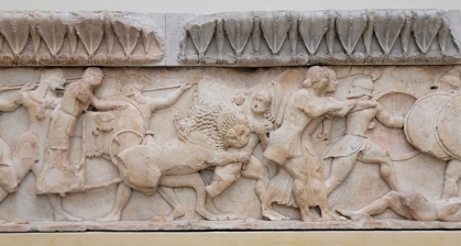 Ancient Greek sculptured frieze of soldier being attacked by a lion.