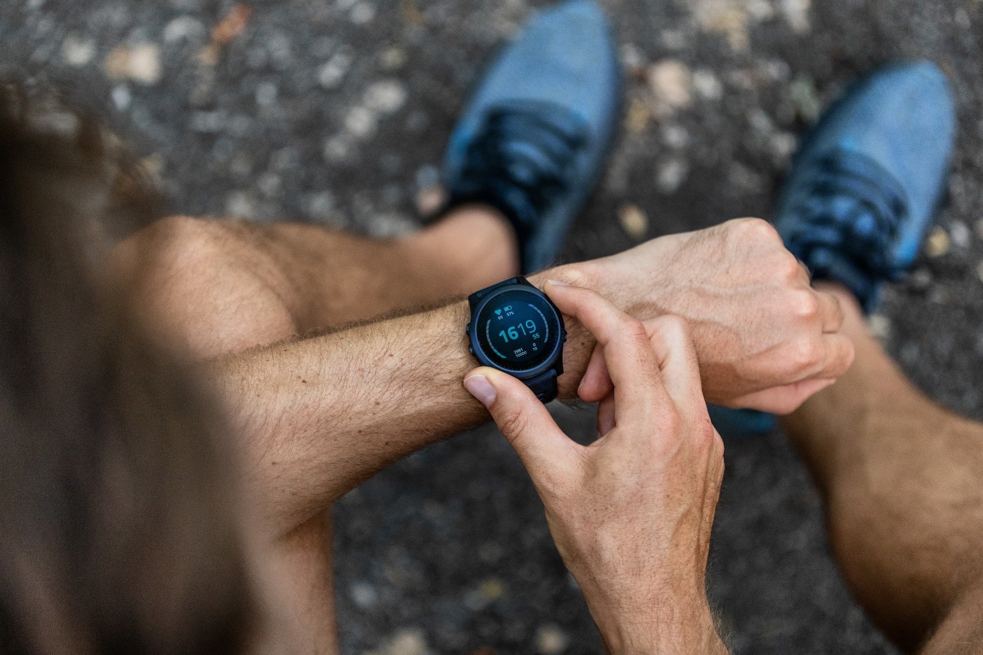 Fit man checking smart watch wearable technology sport smartwatch on fitness run walk outside.