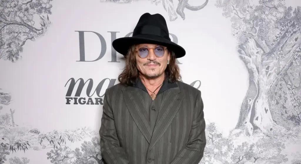 Johnny Depp Brings Dior and Spotlight to Spain’s Screen Tourism Gem Johnny Depp wearing a hat and striped suit at a Dior promotional event
