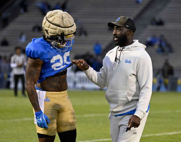 Head coach DeShaun Foster of the UCLA Bruins talks with...