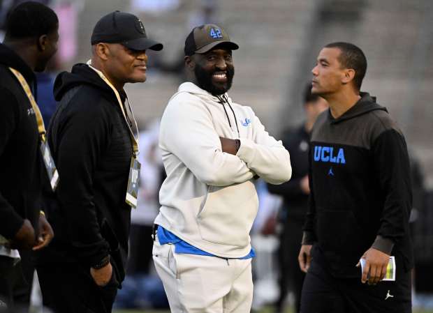 Head coach DeShaun Foster, center, with coach Ken Norton Jr.,...