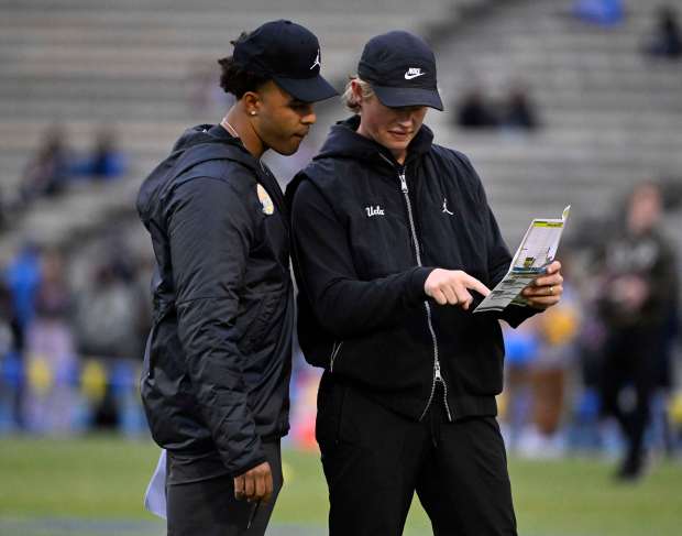Defensive assistant Shea Pitts, left, long with coach Jerry Neuheisel...