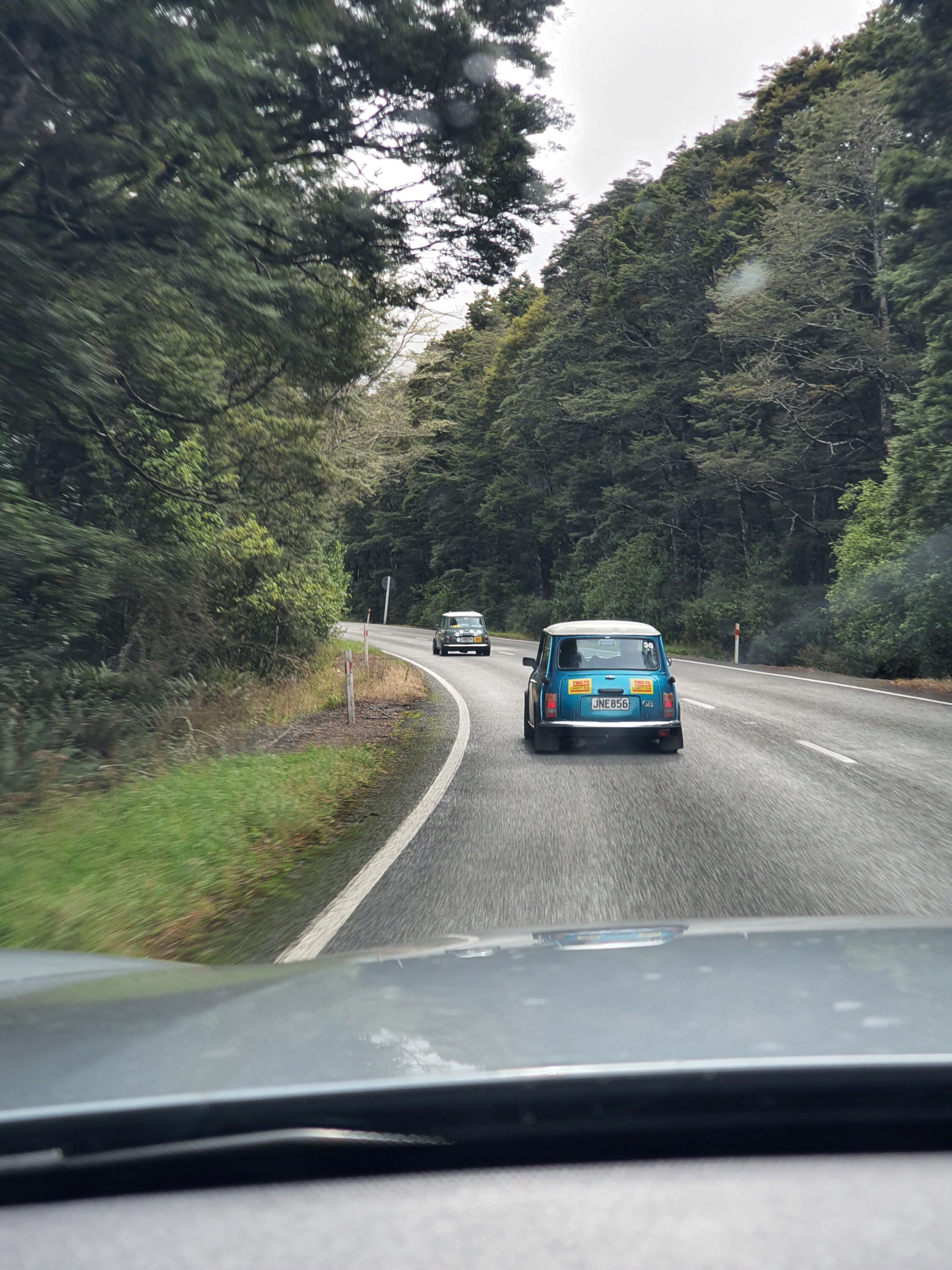 Two classic Minis drive through the winding roads of Lewis Pass in New Zealand's South Island on the 2025 Pork Pie Charity Run.
