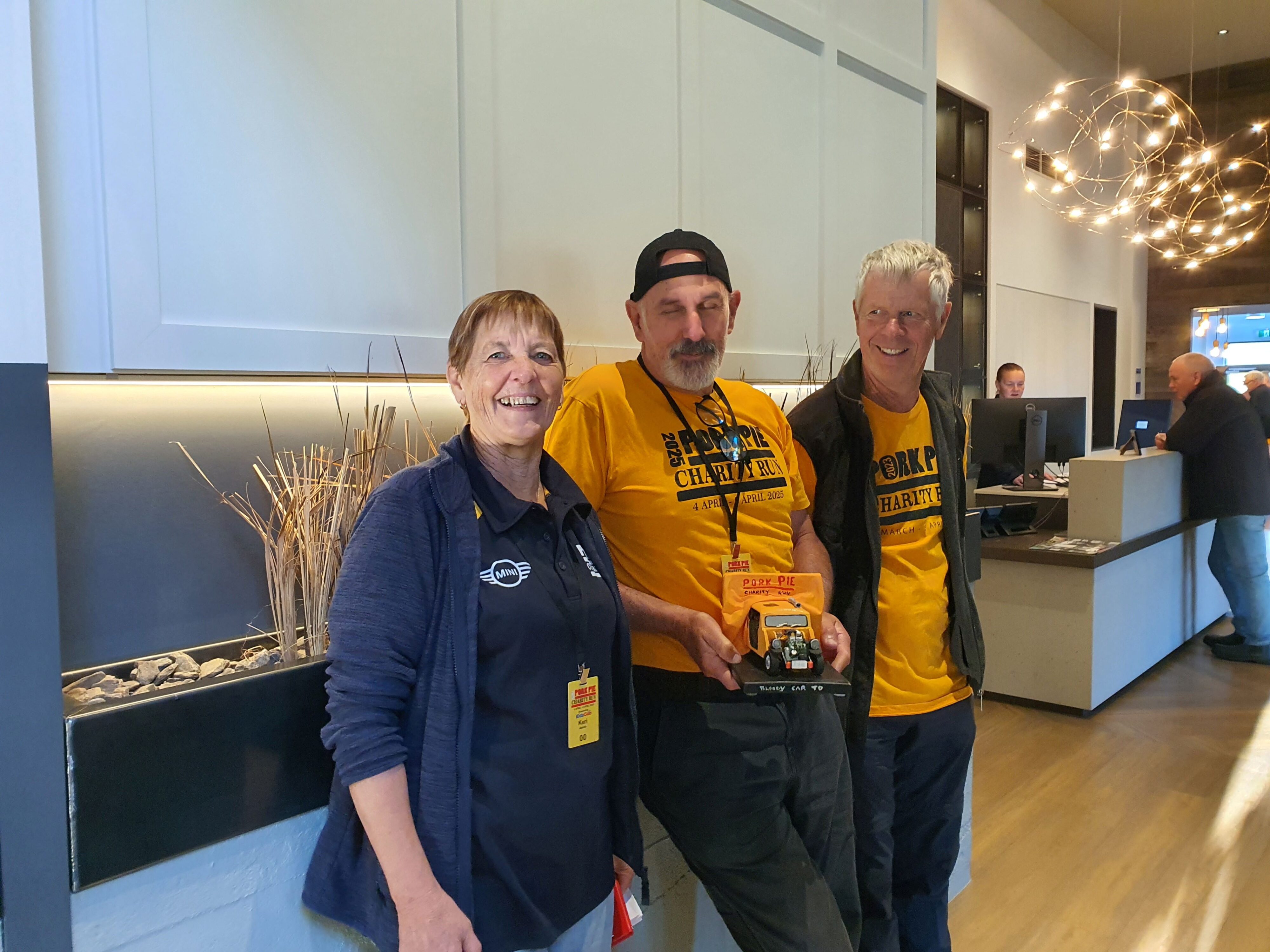 Keri Hollamby, Kevin Hollamby and Peter Bjarnesen pictured with a Mini trophy on the 2025 Pork Pie Charity Run.