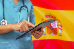 Spanish flag and doctor representing maternity care in Spain for expat families.