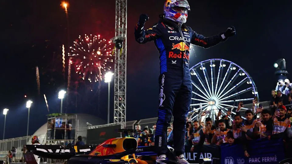 Max Verstappen stands on his car to celebrate winning the Bahrain Grand Prix in 2024, with fireworks exploding in the background