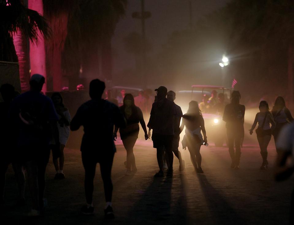 Campers are silhouetted as they arrive on the first night of Coachella in Indio.
