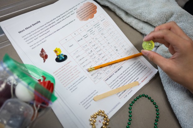 Leo Zhang, 12, looks over his notes from a density and buoyancy test with the the Chicago Pre-College Science and Engineering Program at Kenwood Academy High School. (Audrey Richardson/Chicago Tribune)