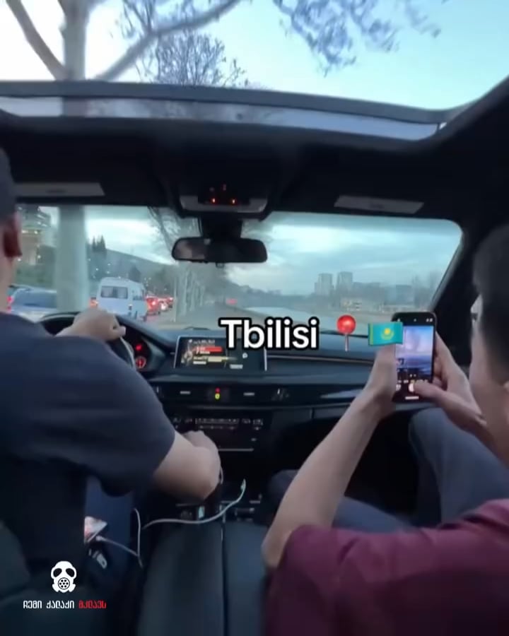 Kazakh foreigners driving on sidewalk during rush hour.