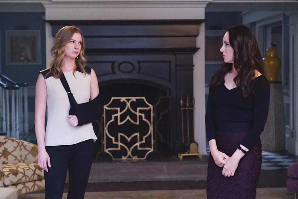 A still from "Revenge" season four featuring Emily Vancamp wearing a black cast and Madeleine Stowe wearing a black shirt and a purple skirt. They're looking at each other.