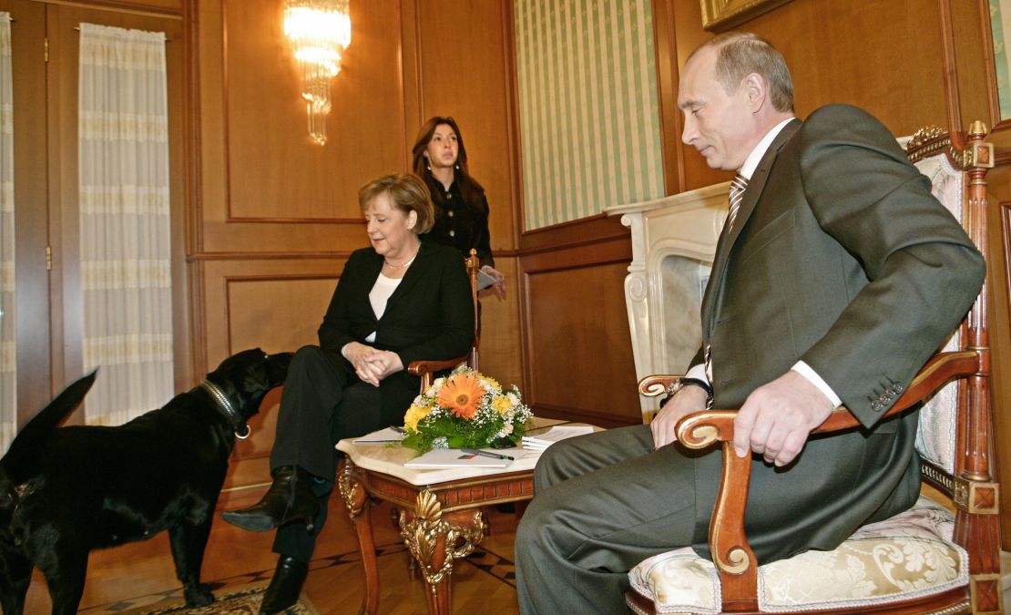Russian President Vladimir Putin looks on as his dog Kuni approaches the Germany Chancellor Angela Merkel in Sochi in January 2007.