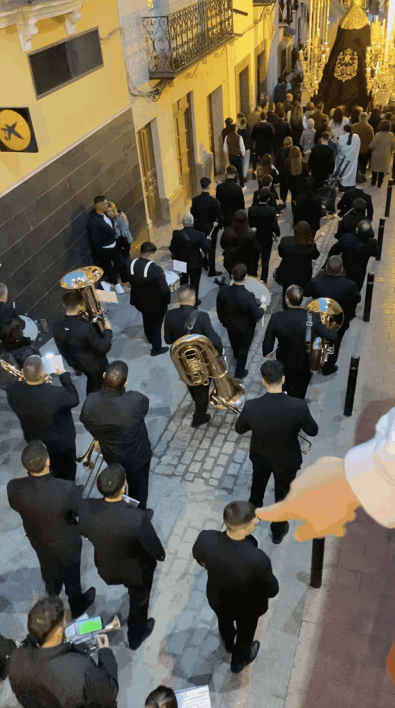 The Most Spanish Thing Ever- A Musician Marching During a Semana Santa Celebration in Alcala del Valle Has a Live Football Match Streaming on His Phone On Top of His Music Notes During the Procession