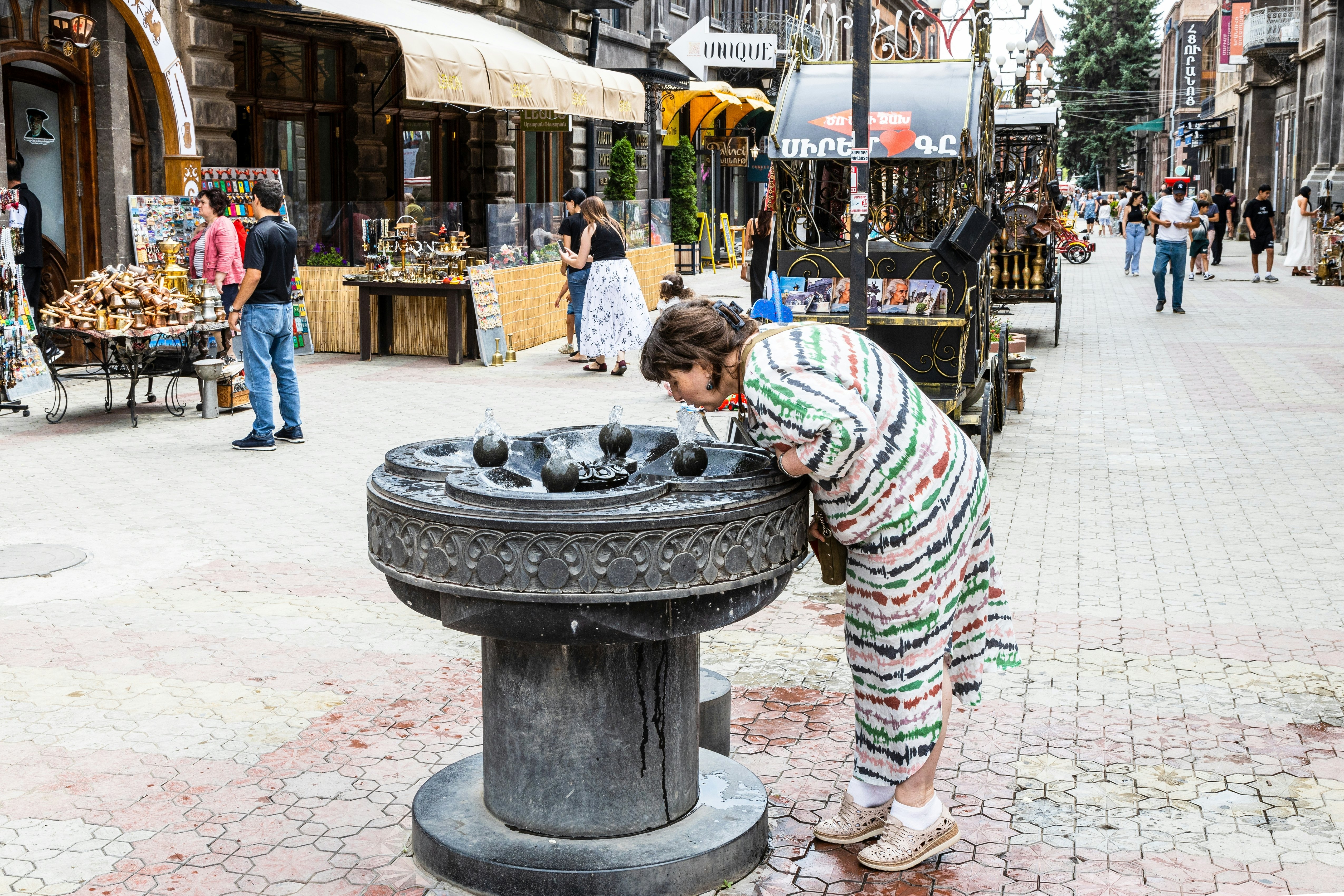Gyumri, Armenia - July 19, 2024: drinking water fountain on Abovyan pedestrian Street in old town of Gyumri city on cloudy summer day