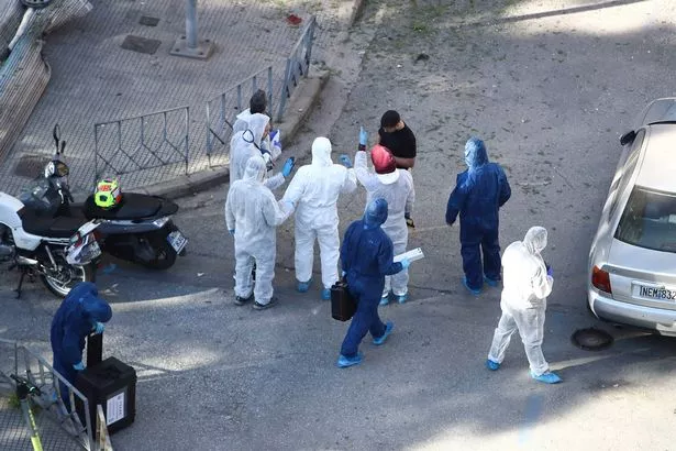 Greek police forensic experts search the area where a 38-year-old woman was killed early Saturday amid a rise in domestic extremism. 