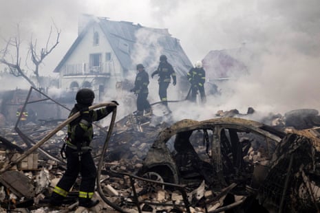 Emergency workers extinguish fire in the debris of a house that was destroyed in a Russian strike in Markhalivka, in the Kyiv region.