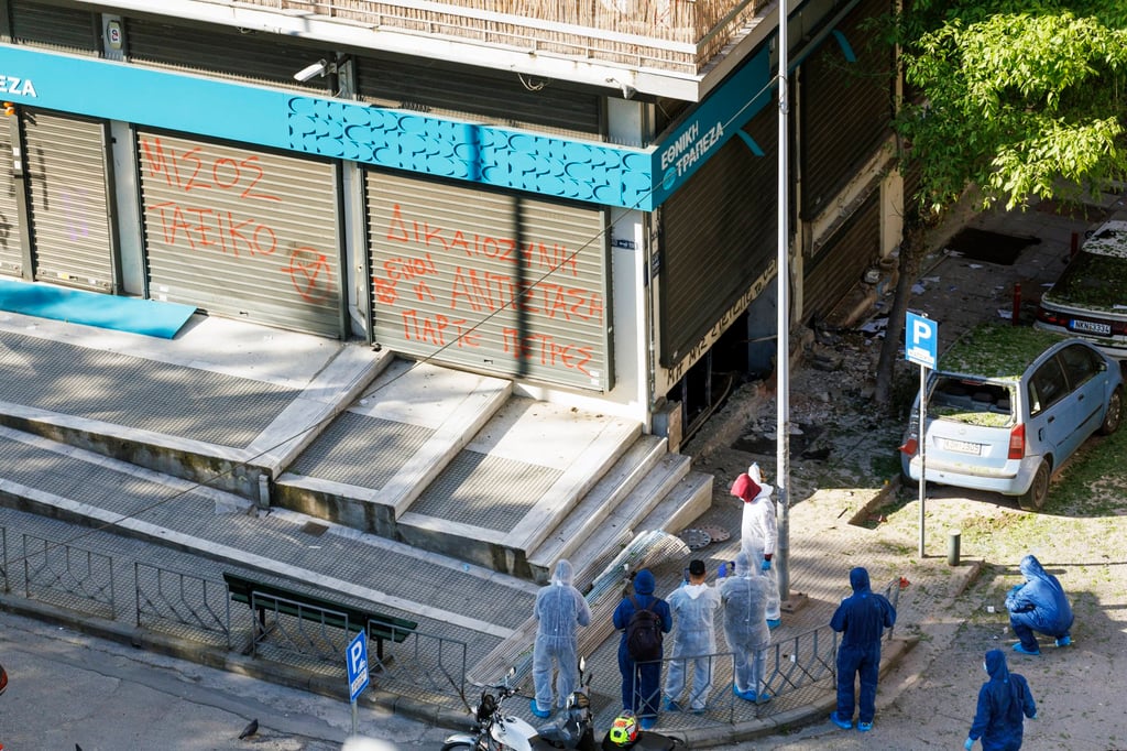 Forensic experts examine the area of a bomb explosion outside a bank in Thessaloniki, Greece, on Saturday. EPA-EFE Forensic experts examine the area of a bomb explosion outside a bank in Thessaloniki, Greece, on Saturday. EPA-EFE