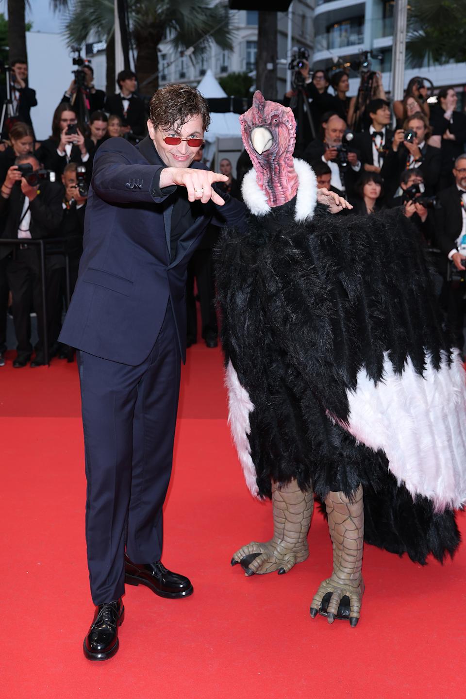 Raphaël Quenard and someone in a bird costume on the red carpet. 