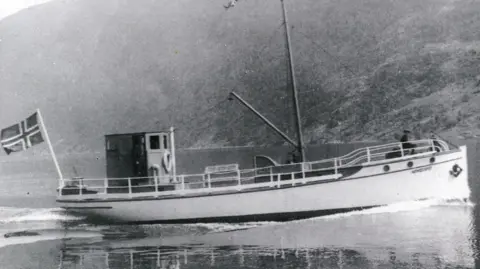 The Liberation Convoy An old pic of a fishing boat in black and white. It appears to have a Norwegian flag waving on its back end 