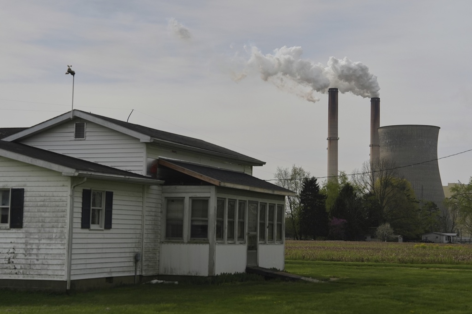 A small home stand in front of a coal-fired power plant