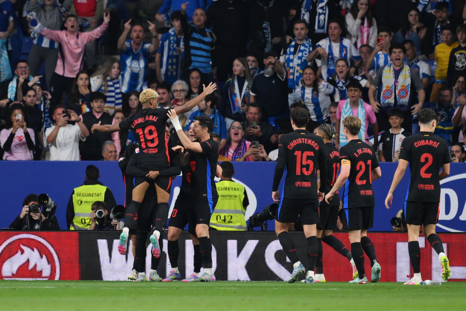 BARCELONA, SPAIN - MAY 15: Lamine Yamal of FC Barcelona celebrates scoring his team's first goal with teammates in front of fans of RCD Espanyol during the LaLiga match between RCD Espanyol de Barcelona and FC Barcelona at RCDE Stadium on May 15, 2025 in Barcelona, Spain.