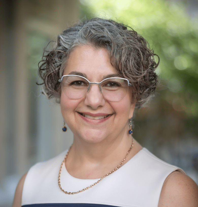 Shows a smiling woman with glasses who doesn't look like a nursing leader, but she is!
