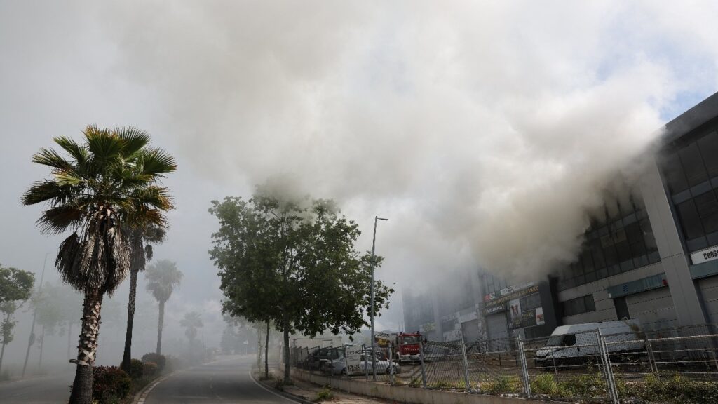 A picture taken on May 10, 2025 shows smoke billowing from a building storing pool cleaning products, in the coastal city of Vilanova i la Geltru, south of Barcelona.
