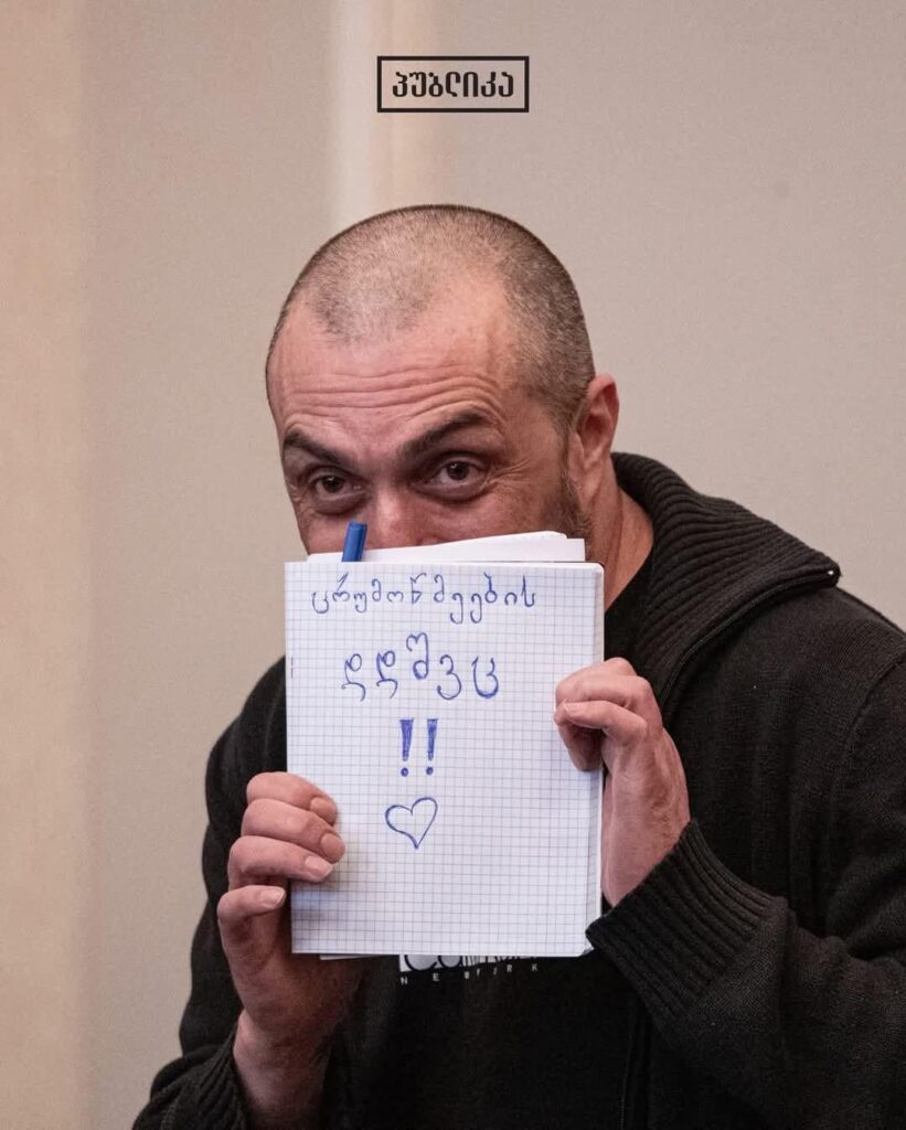 "F*ck False Witnesses" - political prisoner, Giorgi Akhobadze, holding a sign during his court trial