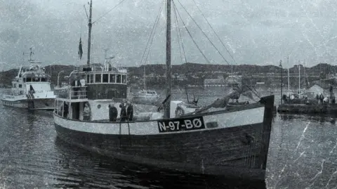 The Liberation Convoy A black and white picture of a sailing boat called the M/K Andholmen. It has N-97-BO written on the side and other boats can be seen behind it 