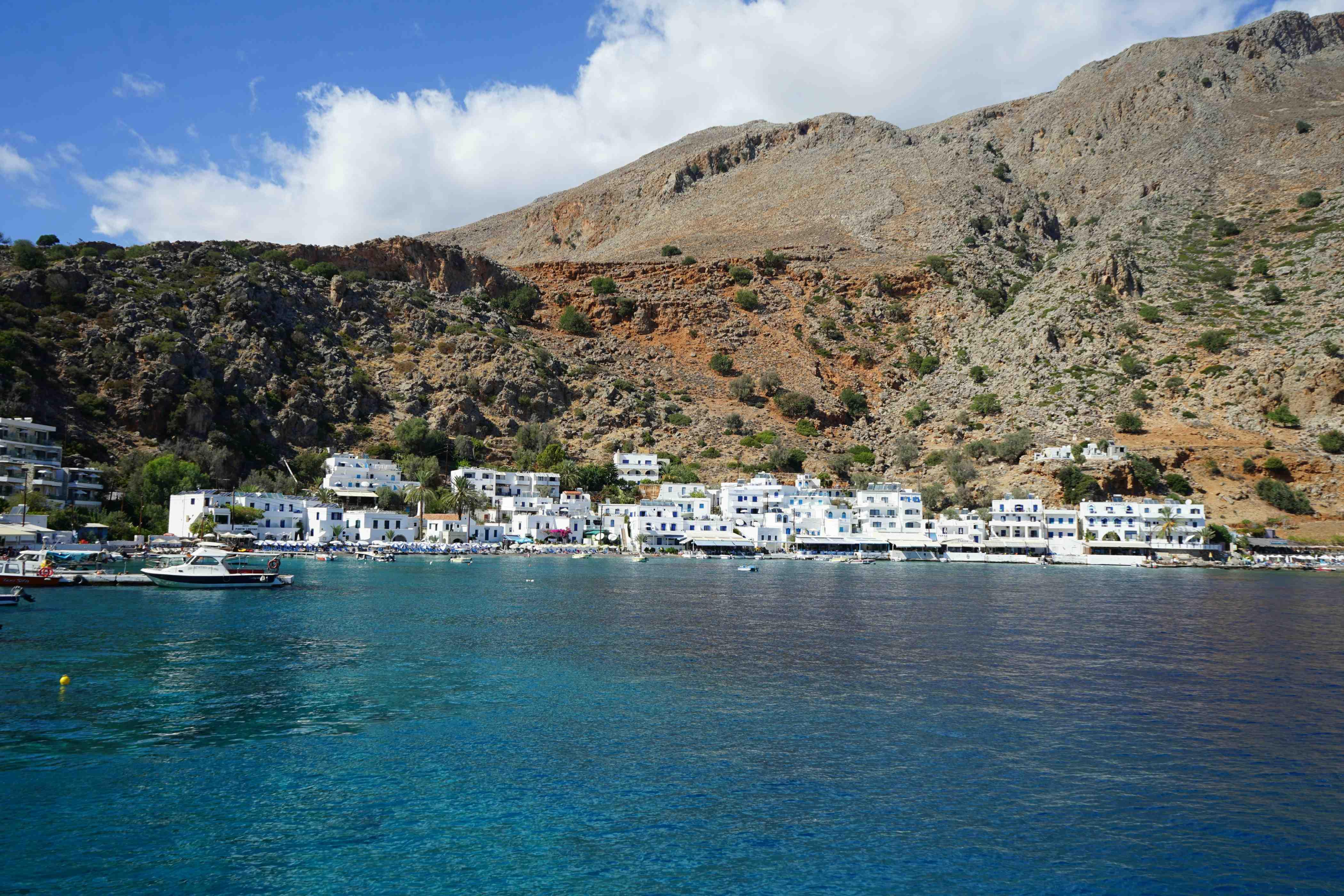 A group of boats and boathouses are pictured on the island of Crete.