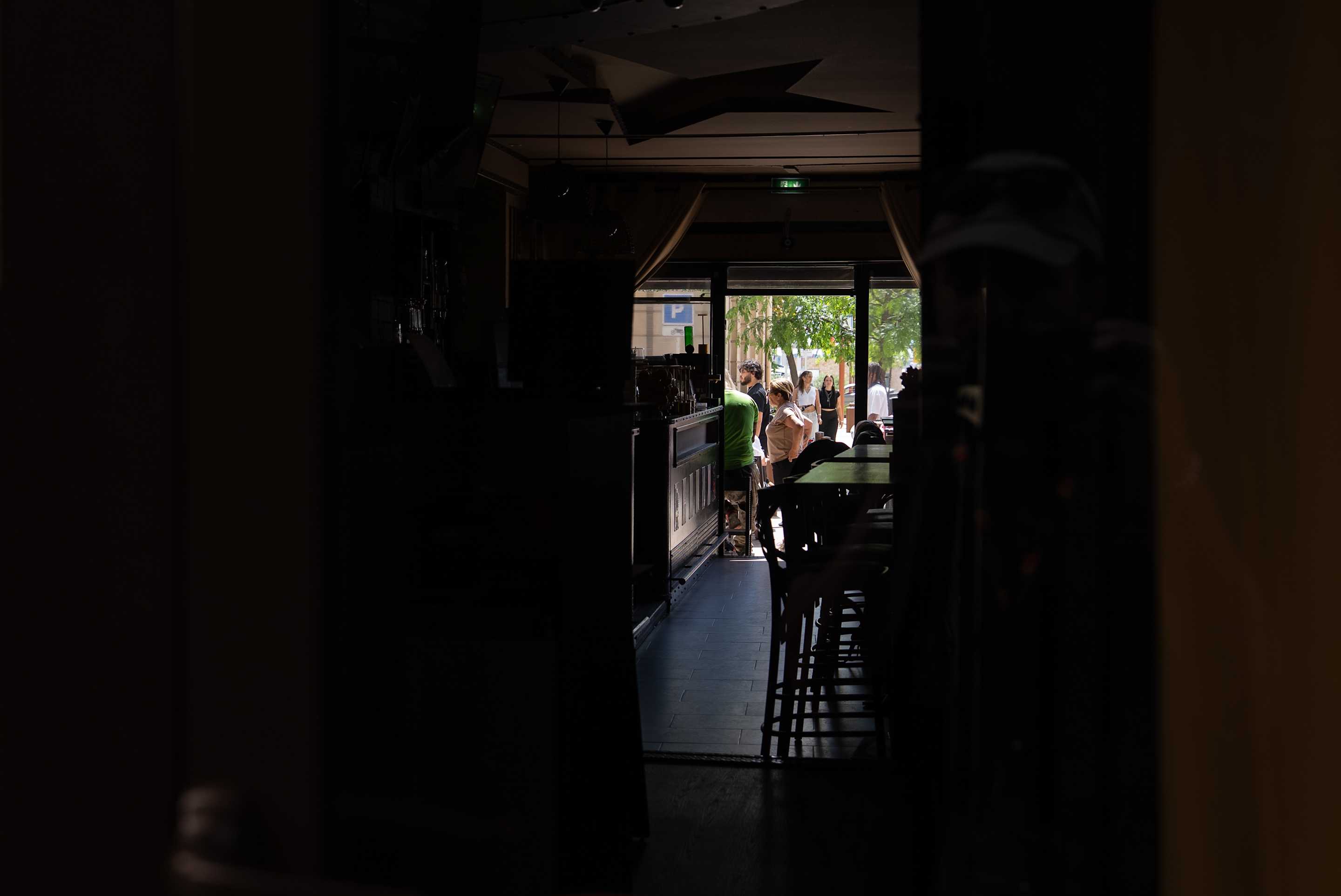Several people seen through an unlit corridor.