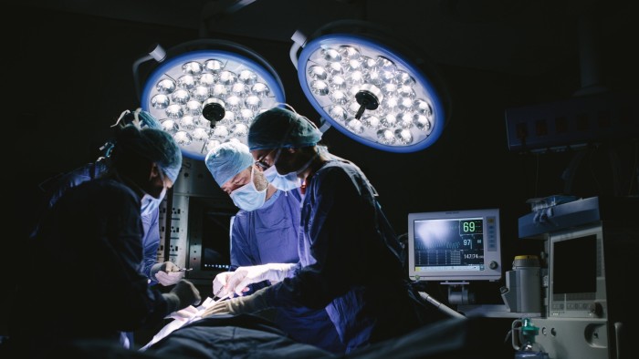 A team of surgeons perform an operation on a patient